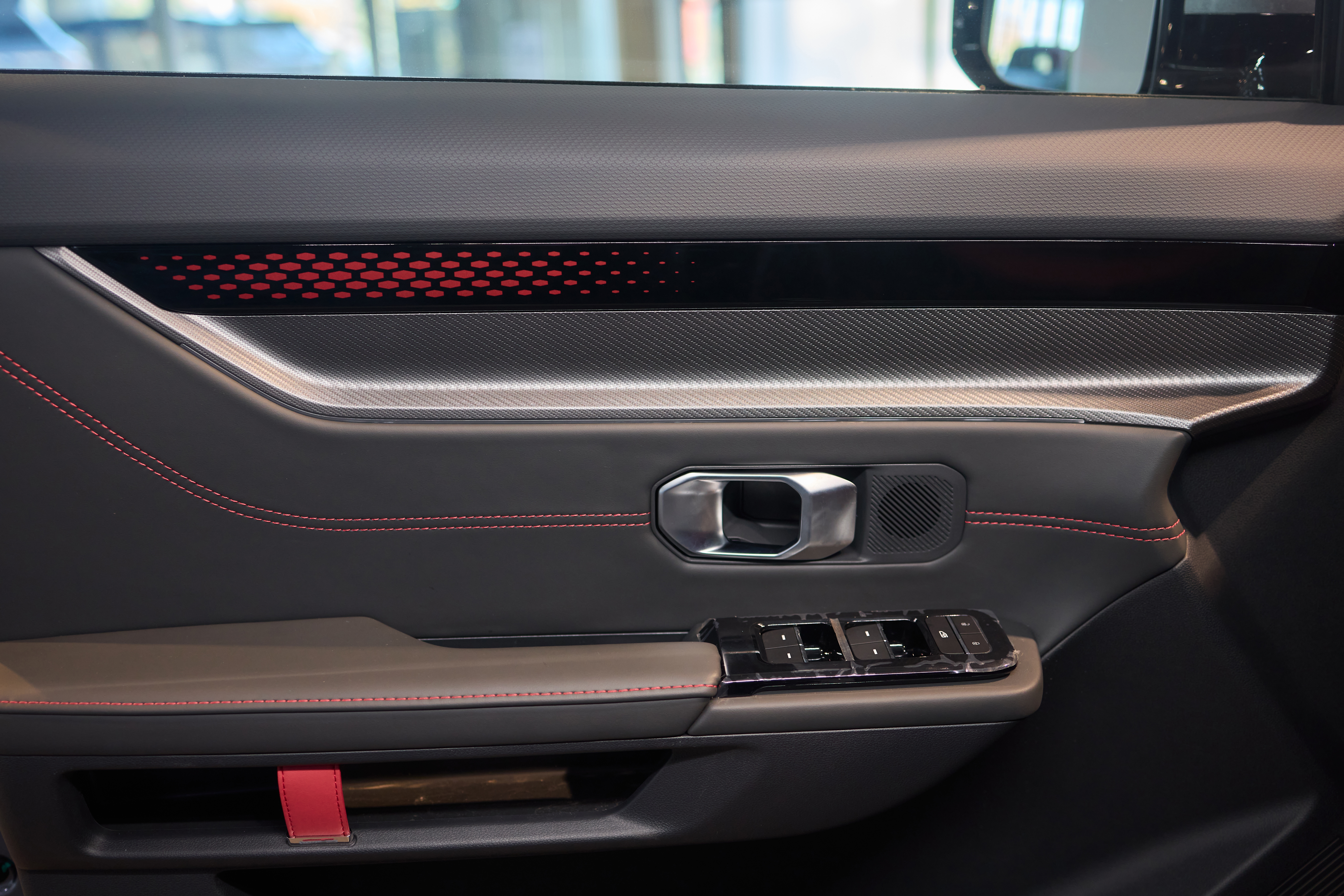 a-closeup-view-of-a-modern-car-door-interior-that-highlights-sleek-carbon-fiber-and-stylish-ambient